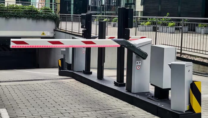 Integrating with broader security and management systems | tycoonstory media Boom gates at an entryway, designed to control access to a parking area or building, ensuring security and proper traffic management at the site.