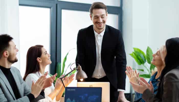 Investing in professional development | tycoonstory media Office team applauding their manager during a presentation, reflecting motivation, leadership, and a healthy employee environment.