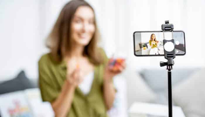 An influencer recording a video for social media, highlighting the role of digital marketing strategies through content creation and influencer marketing.