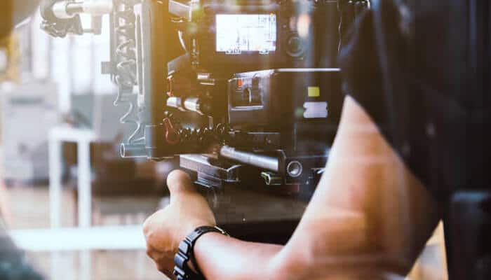 Production expertise as transferable skill | tycoonstory media A person operating a professional camera, showcasing production expertise. This skill, similar to the work of brian quinn, is transferable across various industries.