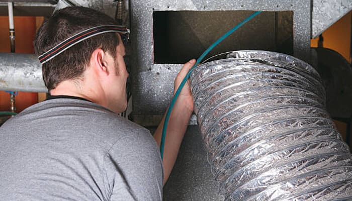 Safety is a prerequisite that cannot be compromised | tycoonstory media Proper duct inspection showing a technician examining flexible air ducts inside an hvac system to identify leaks or blockages.