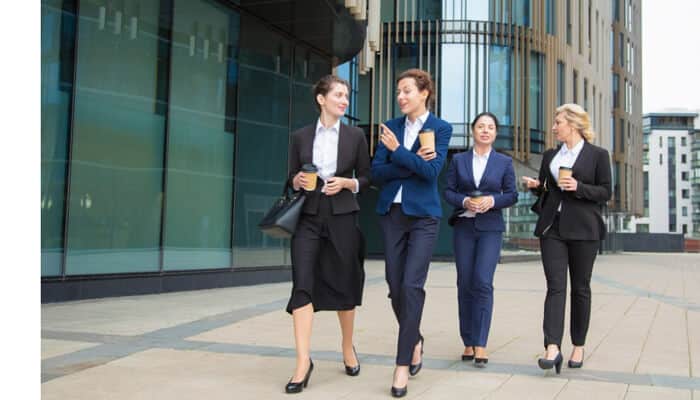 Business casual shoes Professionals walking together outside a modern office building wearing business casual shoes and formal work attire