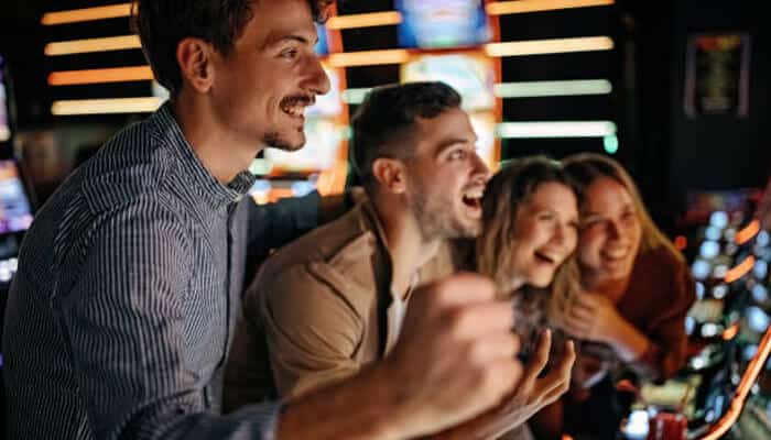 Types of free credit no deposit offers | tycoonstory media A group of friends enjoying themselves at a casino, celebrating their wins while playing, highlighting the fun of using free credit no deposit offers in online gaming.
