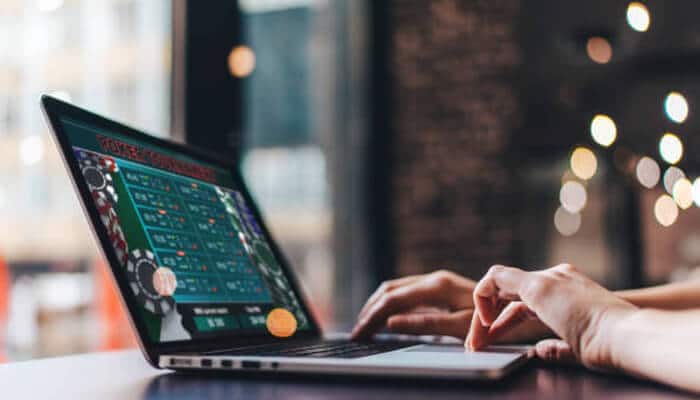A guided tour of the 99odds platform 1 | tycoonstory media Person using a laptop to browse an online betting platform with casino game options, illustrating the digital sports and gaming experience on 99odds.