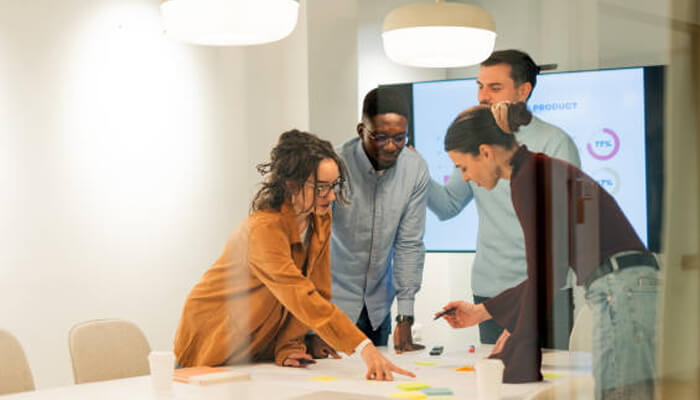 Advisory depth that extends beyond the ledger | tycoonstory media Professionals collaborating in a modern office, discussing ideas with sticky notes. Their teamwork highlights how industry expertise matters in achieving results..