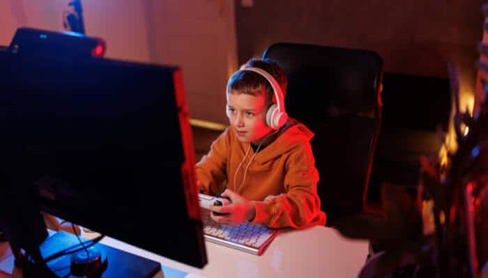 Educational utility on the big screen | tycoonstory media A young child playing a game on the computer, fully immersed in an educational experience, showcasing how scratchjr for pc can be a fun and interactive way for kids to learn coding.