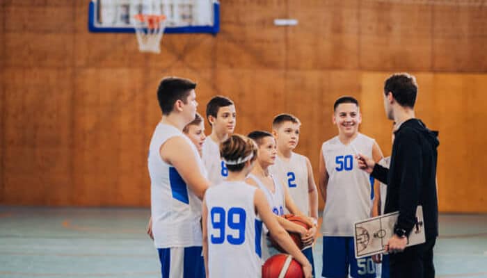 Essential leadership skills for sports administrators | tycoonstory media A sports coach engaging with a group of young athletes, showcasing the importance of leadership in shaping the future of sports administration at the grassroots level.