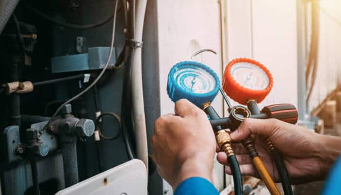 How hvac systems support healthier more productive indoor environments | tycoonstory media A technician checking hvac system pressure gauges, ensuring proper functioning to maintain indoor air quality and a healthier, more productive indoor environment.