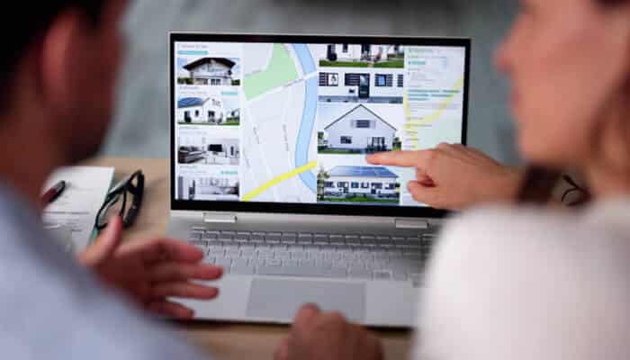 Professional photography is non-negotiable | tycoonstory media Homebuyers reviewing property listings on a laptop map while planning strategies for selling your home quickly and profitably.