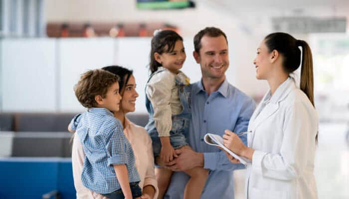 Schedule regular health check-ups | tycoonstory media A family smiling and interacting with a doctor, demonstrating the importance of regular health check-ups to keep your family healthy and happy.