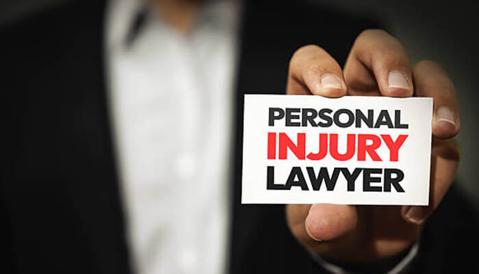 The job of a personal injury lawyer and how to select one | tycoonstory media Personal injury claim - a person holding a business card with the words'Personal Injury Lawyer,' showcasing their expertise in handling legal matters.
