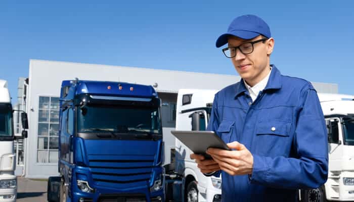 The shift to automation | tycoonstory media Fleet manager using a tablet to monitor trucks and oversee fleet maintenance management operations.