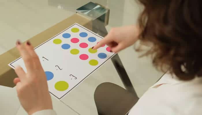 Visual-spatial skills assessment | tycoonstory media Neuropsychologists assess visual-spatial skills using a test with colored circles, where the individual points at numbers to identify patterns.