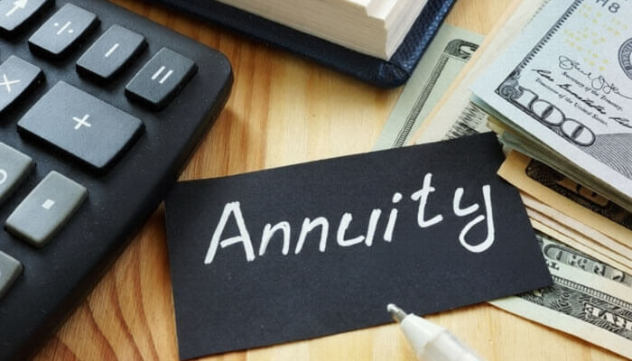 Annuity payments spread out your tax burden | tycoonstory media An image showing a calculator, a stack of dollar bills, and a note with the word annuity. This relates to the lottery payout option, where winnings can be paid periodically.