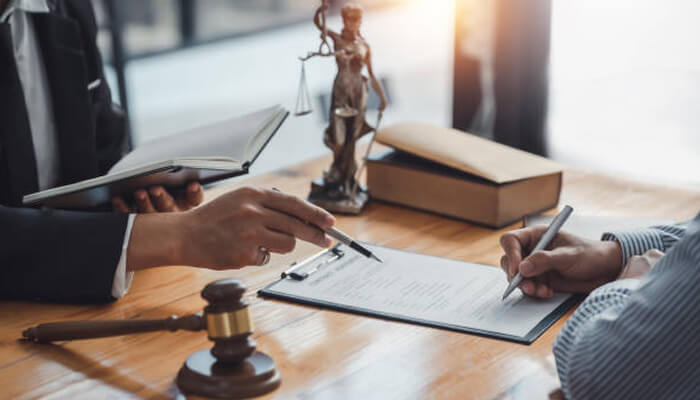 Appeals require more than filling out forms | tycoonstory media Lawyer and client discussing a document with legal tools in the background, focusing on a Denied L&I Claim and the process of filing an appeal.
