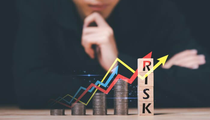 Assess your financial vulnerability | tycoonstory media An individual analyzing financial data with stacked coins and upward graphs, symbolizing the concept of managing personal risk in financial decisions and investments.