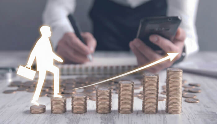 Better career and salary prospects | tycoonstory media Person walking up a stack of coins, symbolizing career growth, with a smartphone in hand, representing the opportunities from pursuing an mba in australia.