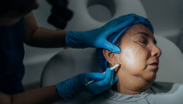 Clinical outcomes and longevity | tycoonstory media A patient undergoing a facial procedure with markings made by a medical professional, reflecting the expertise of renowned surgeon dr. Andrew jacono in cosmetic treatments.