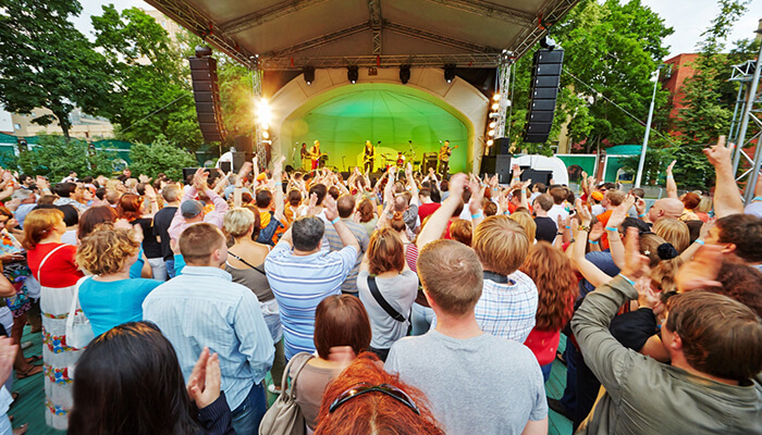 Enhancing community engagement and learning | tycoonstory media A vibrant crowd enjoying a concert in flexible outdoor spaces, where the stage and audience are well integrated, creating an engaging and dynamic environment for the event.