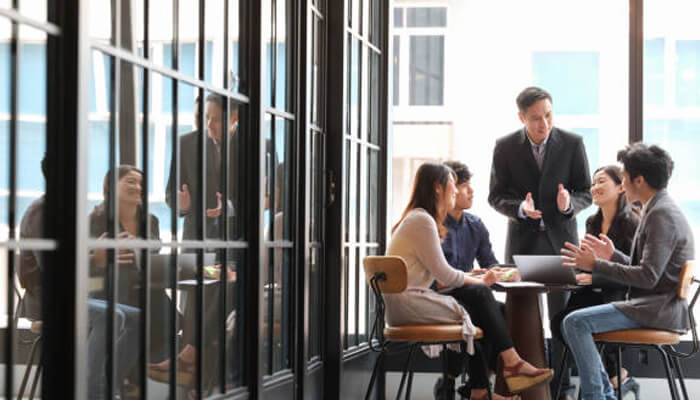 Essential steps to establish your presence | tycoonstory media Professionals collaborating in a modern office, reflecting the teamwork and strategy involved in launching your startup in singapore for business success.