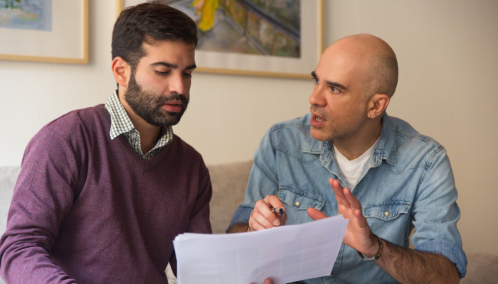 Evidence that strengthens slip and fall injury claims | tycoonstory media Two individuals are discussing documents, with one explaining something to the other. This scene highlights the importance of gathering evidence that strengthens fall injury claims in legal cases.