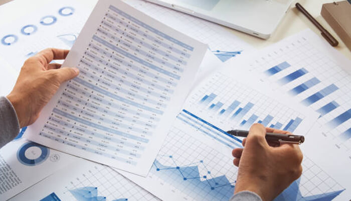 Financial risks that rarely make the spreadsheet | tycoonstory media A person reviewing financial data, including charts and graphs, to analyze financial growth strategies and assess business performance.