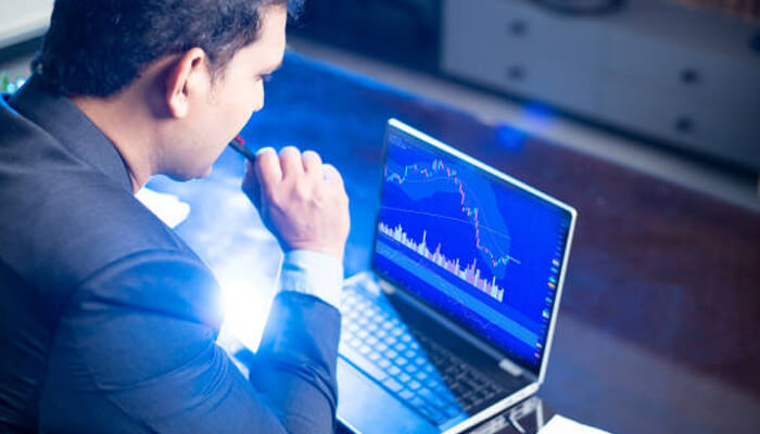 How smart alerts work | tycoonstory media A person analyzing stock market trends on a laptop, focused on financial data and charts, with the use of smart stock alerts to make informed decisions.