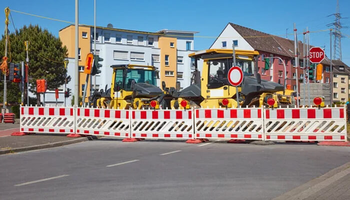 Reduced on-site decision pressure | tycoonstory media Temporary safety barriers are set up around road construction equipment to ensure safety while work is being done in the area.