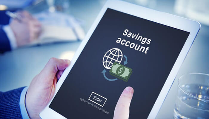 Sa | tycoonstory media A person using a tablet to access a savings accounts page online, with an icon representing global transactions and money. The screen shows options to sign in for more privileges.