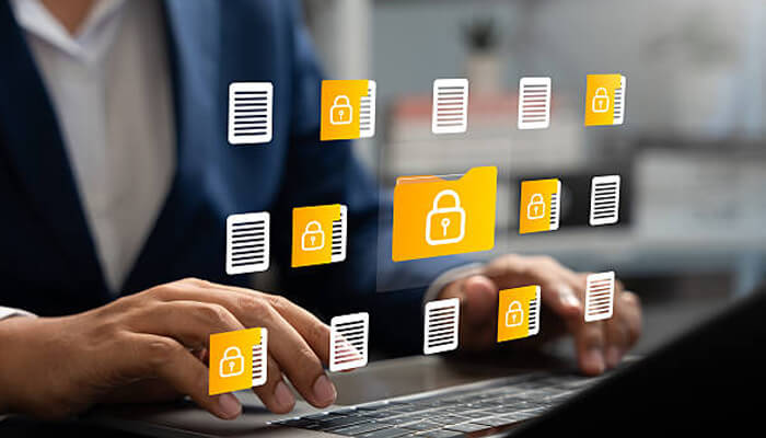 Safeguarding data | tycoonstory media A person using a laptop with digital icons representing secure files and folders. This image highlights the importance of protecting shared drives and safeguarding sensitive data in the digital workspace.