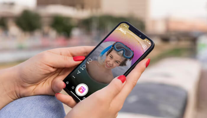 The best platforms to get more instagram reels views | tycoonstory media A person is holding a phone, watching an instagram reel. This visual emphasizes the importance of platforms and strategies to increase instagram reels views.