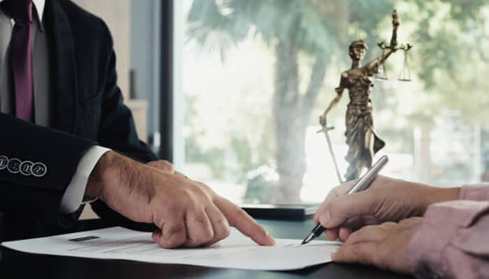 The role of legal representation | tycoonstory media A lawyer and client review and sign documents, emphasizing the role of legal representation for injured rail workers seeking justice and fair compensation.