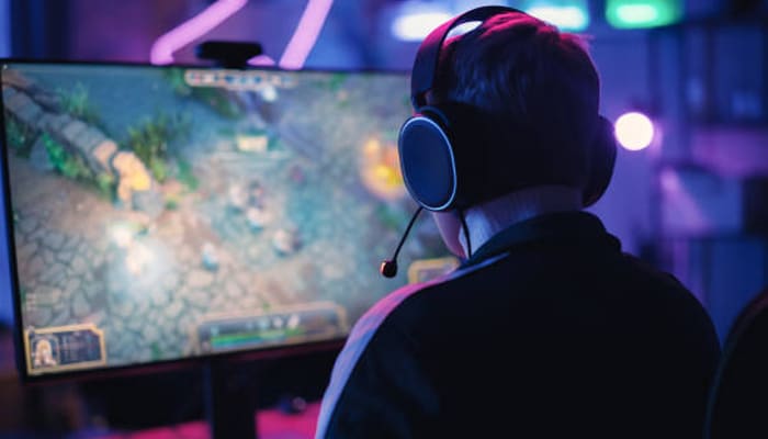 Untitled-1 | tycoonstory media Playmyworld gamer wearing a headset while playing on a high-performance pc, showcasing immersive gameplay, online gaming trends, and esports culture.