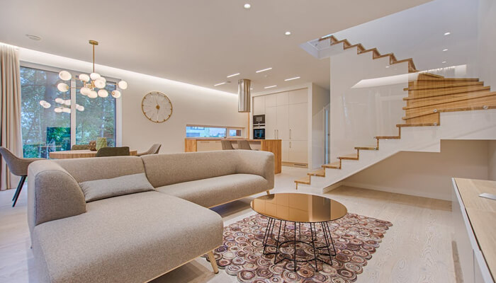 Why high-end materials hold their value | tycoonstory media Modern and spacious living room in luxury homes with stylish furniture, elegant lighting, and a sleek staircase, creating an inviting and high-end atmosphere.