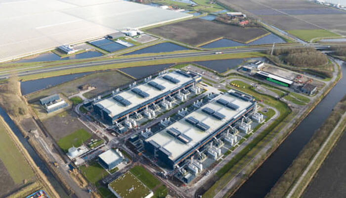 Energy efficiency and sustainability | tycoonstory media Aerial view of a large-scale data center infrastructure, showcasing rows of modern buildings and open fields around the facility.