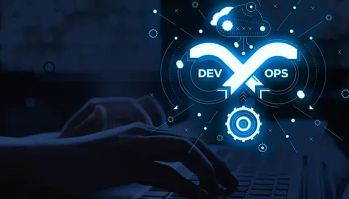 Devops automation | tycoonstory media Devops infrastructure automation concept with cloud, gears, and infinity symbol over a laptop keyboard.