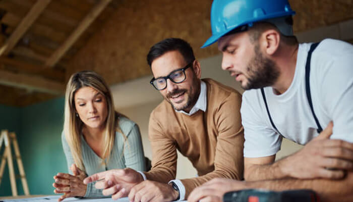 Small details that quietly influence the final outcome | tycoonstory media A group of professionals, including trusted builders, discussing plans for a construction project, showcasing collaboration and expertise in building development.