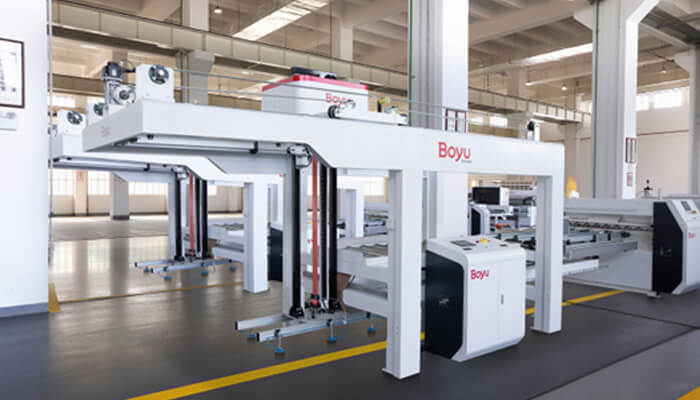 1 4 | tycoonstory media Industrial manufacturing machine in a bright factory, a large white frame labeled 'boyu' with a control console nearby and a yellow safety line on the floor.