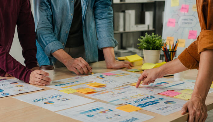 Common strategies behind recent innovative marketing examples 2026 - tycoonstory | tycoonstory media Recent innovative marketing examples 2026 showing a business team reviewing marketing charts, sticky notes, and campaign planning ideas