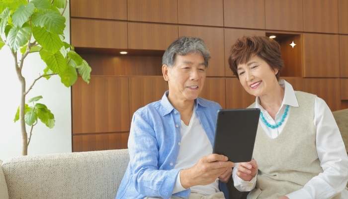 Content that speaks to family concerns | tycoonstory media Senior couple using a tablet at home to explore helpful care communities support and wellness resources.