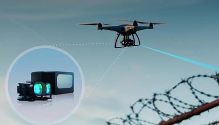 D 3 | tycoonstory media Quadcopter drone filming with a camera on a gimbal; an inset shows the camera gear while flying over a barbed wire fence.