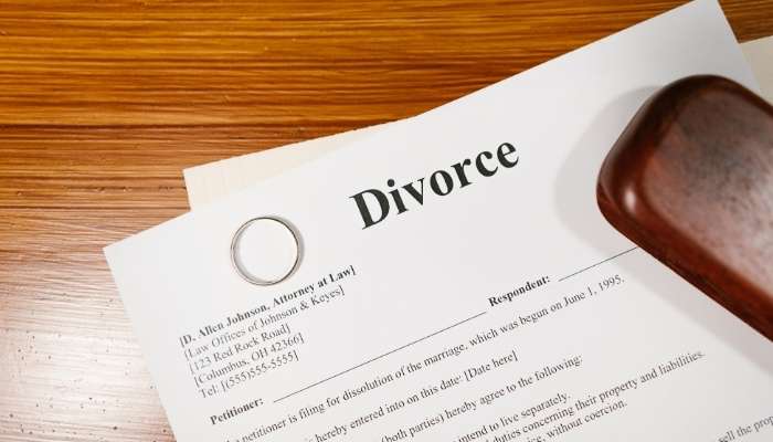 _divorce works | tycoonstory media Divorce papers with wedding ring and gavel, showing legal separation documents and family law process.
