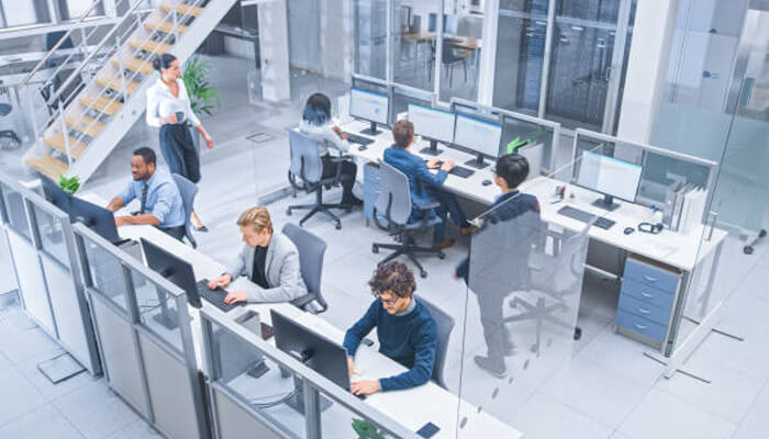 Flexible offices reduce long-term risk | tycoonstory media Modern open-plan workplace with collaborative workstations, showcasing how accessible offices support productivity, teamwork, and employee comfort.