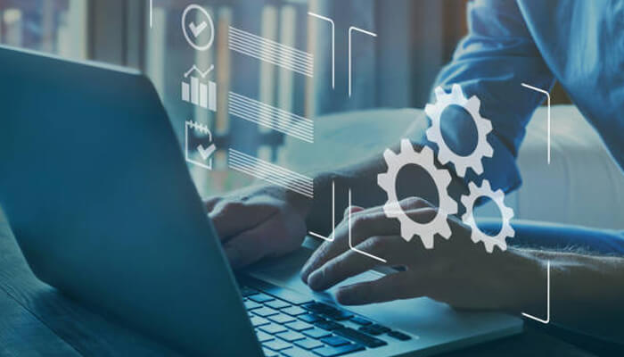Improved workflow automation | tycoonstory media A person using a laptop with digital gears and icons representing the integration of ai tool platforms to enhance productivity and streamline workflows.