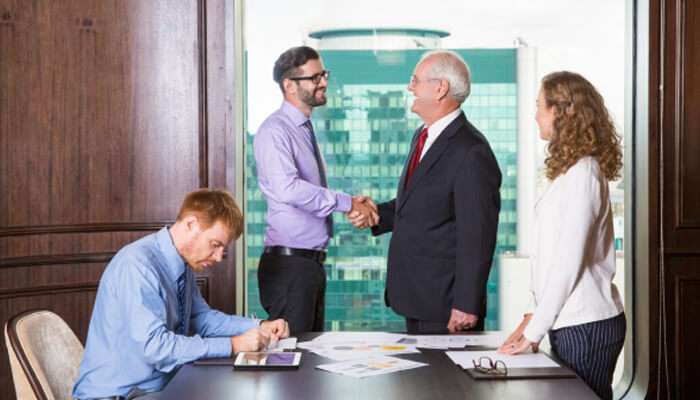 Key services offered by idaho business brokers | tycoonstory media Business professionals shaking hands with the help of business brokers in idaho to finalize a successful deal in a modern office setting.