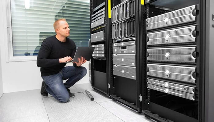 Essential strategies for maintaining continuous operations | tycoonstory media It technician checks server racks to prevent costly it downtime with reliable data center maintenance.