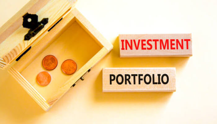 Key tangible assets for portfolio diversification | tycoonstory media Resilient wealth portfolio concept showing investment planning, savings box, and portfolio diversification for long-term financial security.