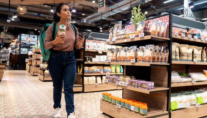 Enhances in-store experience | tycoonstory media Shopper walking through a retail store using digital sign solutions to improve product displays, promotions, and customer engagement.