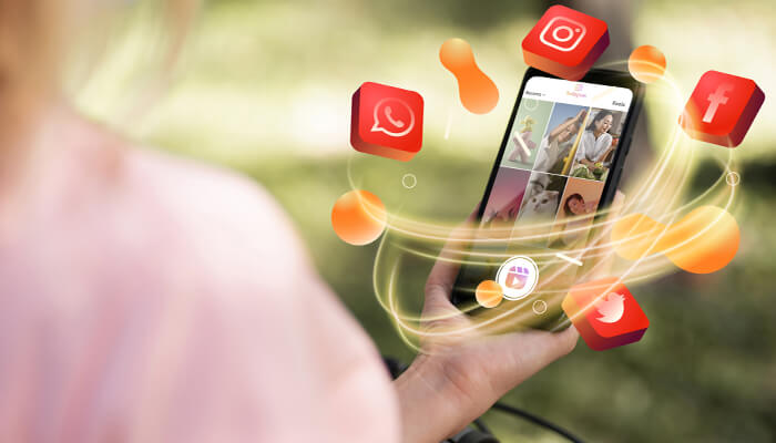 Hfgdfgdf | tycoonstory media Person holding a smartphone with colorful social media icons (instagram, facebook, whatsapp) swirling around it.