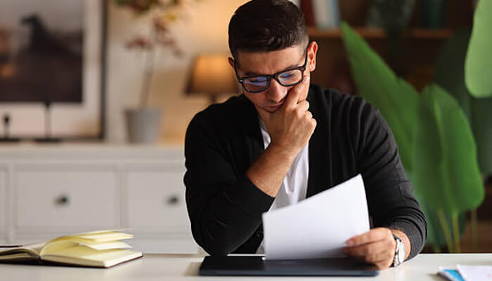 Unique financing challenges | tycoonstory media Business owner reviewing financial paperwork and loan documents while planning a heloc strategy for home equity funding and business cash flow needs.